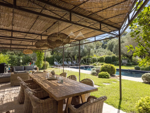 Terrasse en bois avec mobilier, vue sur jardin et piscine dans une villa à Mougins.