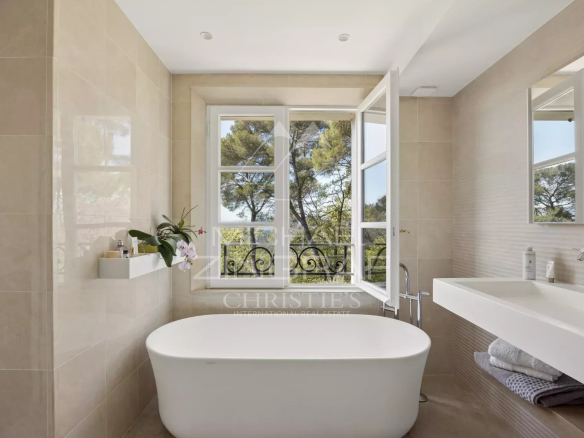 Salle de bain moderne avec baignoire et fenêtres donnant sur la nature à Mougins.
