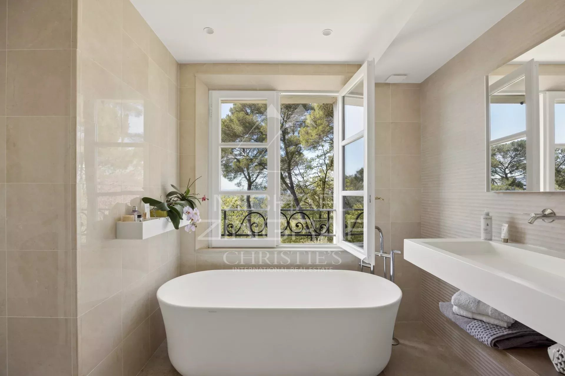 Salle de bain élégante à Mougins Salle de bain moderne avec baignoire et fenêtres donnant sur la nature à Mougins.