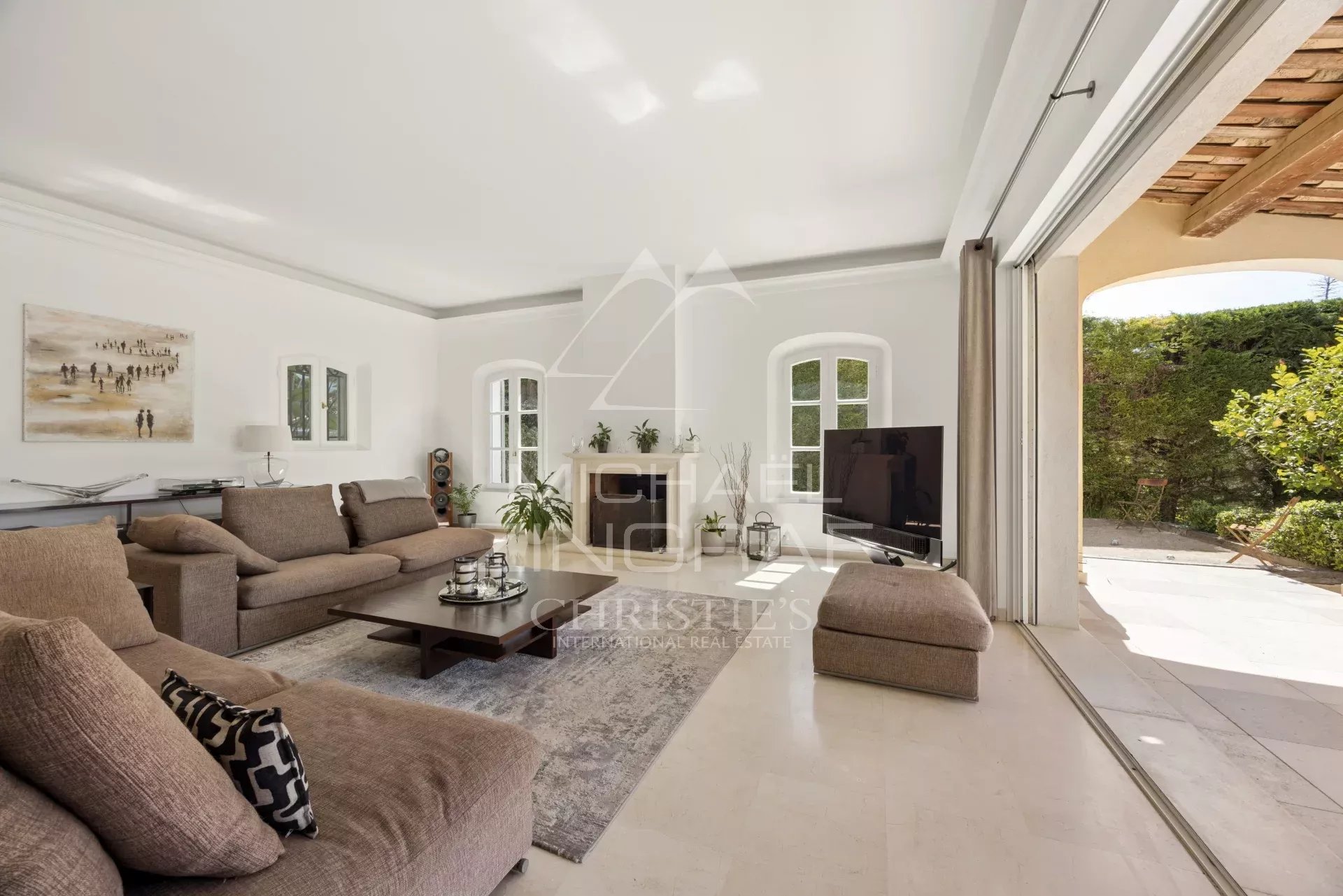 Salon d’une villa à Mougins Intérieur d'une villa à Mougins avec un salon lumineux et moderne, cheminée et accès au jardin.