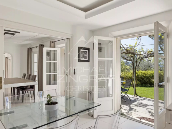Intérieur d'une villa à Mougins avec une salle à manger lumineuse et accès au jardin.
