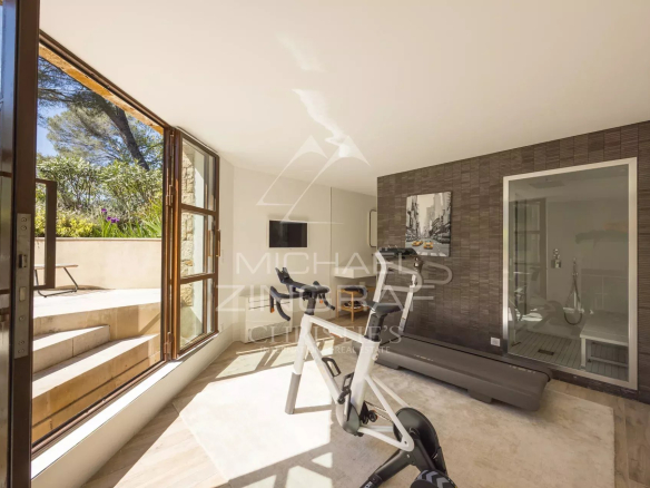 Intérieur d'une villa à Mougins avec un espace de fitness et de grandes fenêtres.