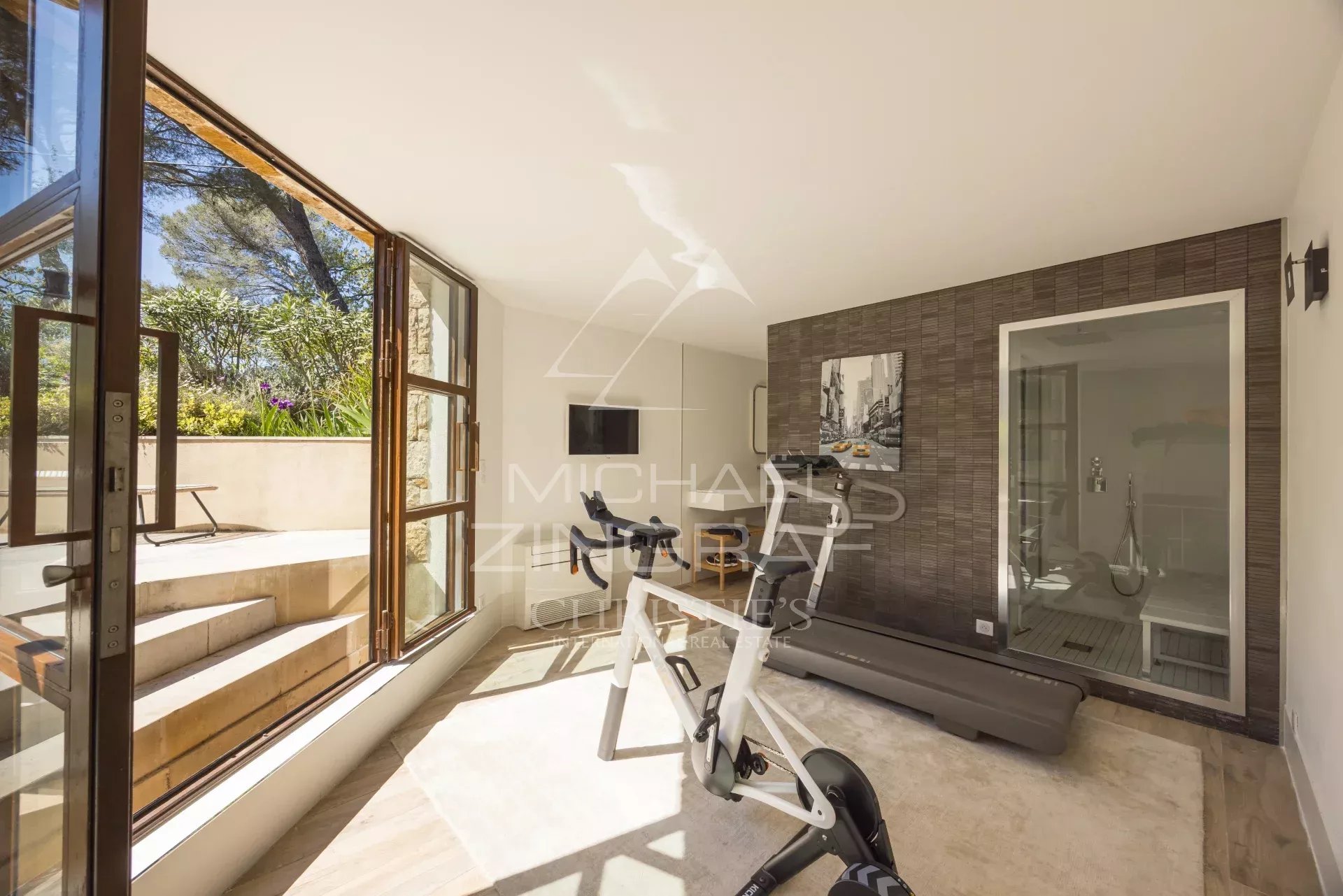 Intérieur d’une villa à Mougins Intérieur d'une villa à Mougins avec un espace de fitness et de grandes fenêtres.