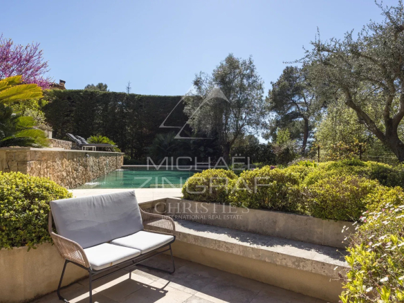 Vue d'une villa avec piscine et jardin paysager à Mougins, ensoleillée et calme.