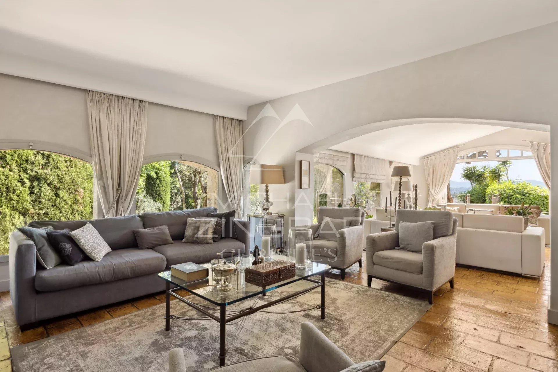 Intérieur d'un mas provençal rénové avec un salon spacieux et lumineux, vue sur les collines.