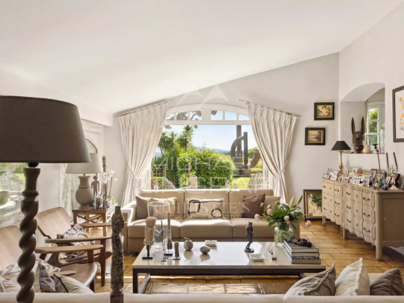 Intérieur d'un mas provençal rénové avec salon lumineux et vue sur les collines.