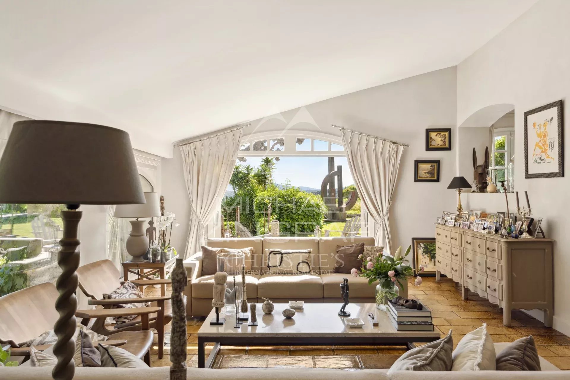 Intérieur d'un mas provençal rénové avec salon lumineux et vue sur les collines.