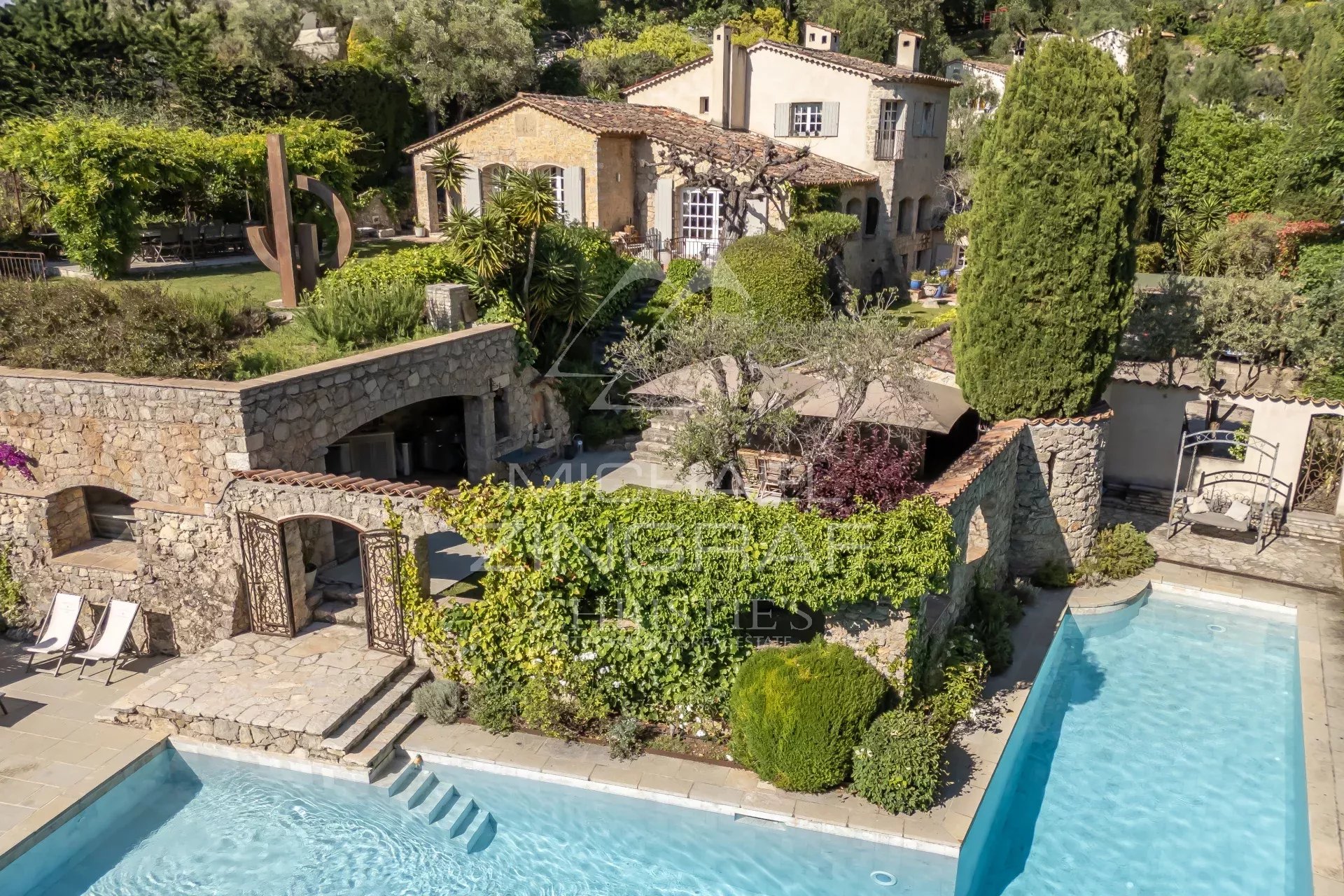 Vue aérienne d'un mas provençal rénové avec piscine et jardin à Mouans-Sartoux.