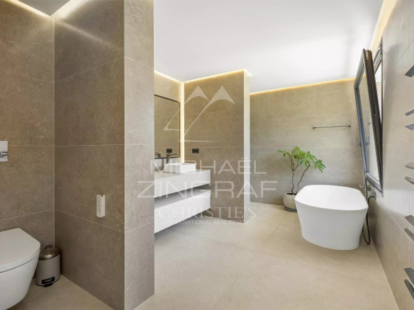 Salle de bain moderne avec baignoire et toilettes dans une villa contemporaine.