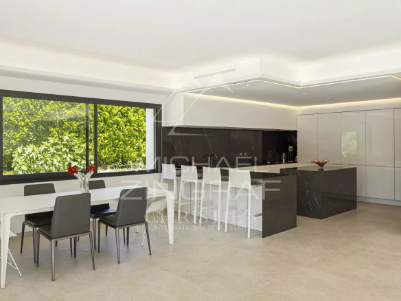 Intérieur d'une villa contemporaine avec salon, salle à manger et cuisine ouverte.