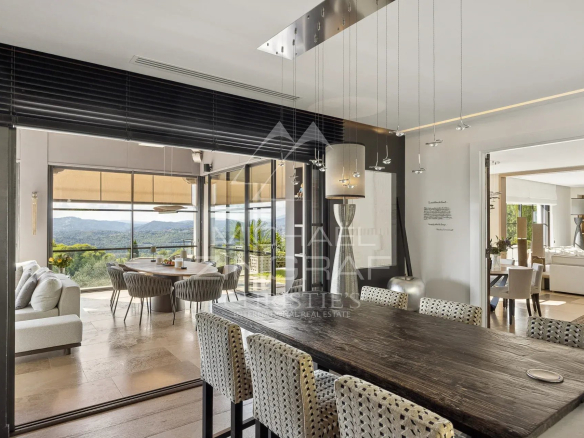 Intérieur d'une bastide moderne avec vue panoramique sur les collines et la baie de Théoule.
