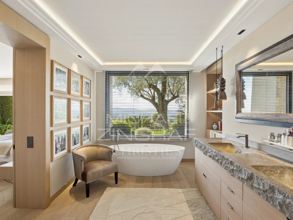 Salle de bain moderne avec baignoire et vue sur l'extérieur, éclairage naturel.