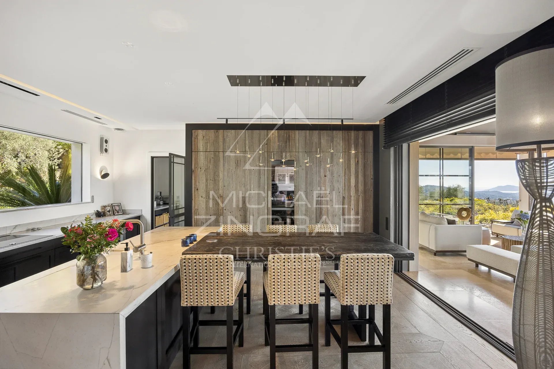 Cuisine d’une bastide moderne à Mouans-Sartoux Intérieur d'une bastide moderne avec cuisine ouverte et vue sur les collines.