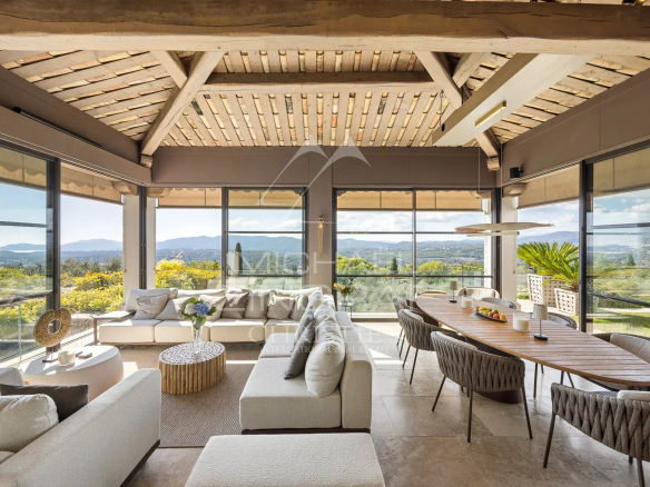 Intérieur d'une bastide moderne avec vue panoramique sur les collines et la baie.