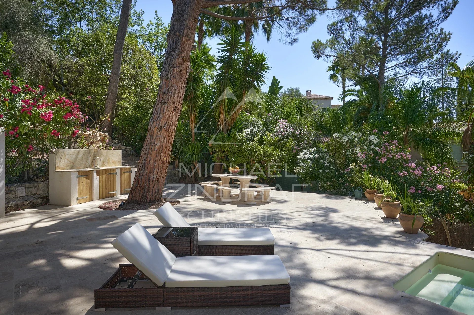 Terrasse de villa à Mougins Terrasse d'une villa à Mougins avec chaises longues et plantes fleuries.