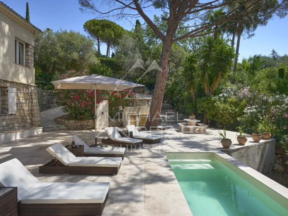 Villa provençale avec piscine et transats dans un jardin verdoyant à Mougins.