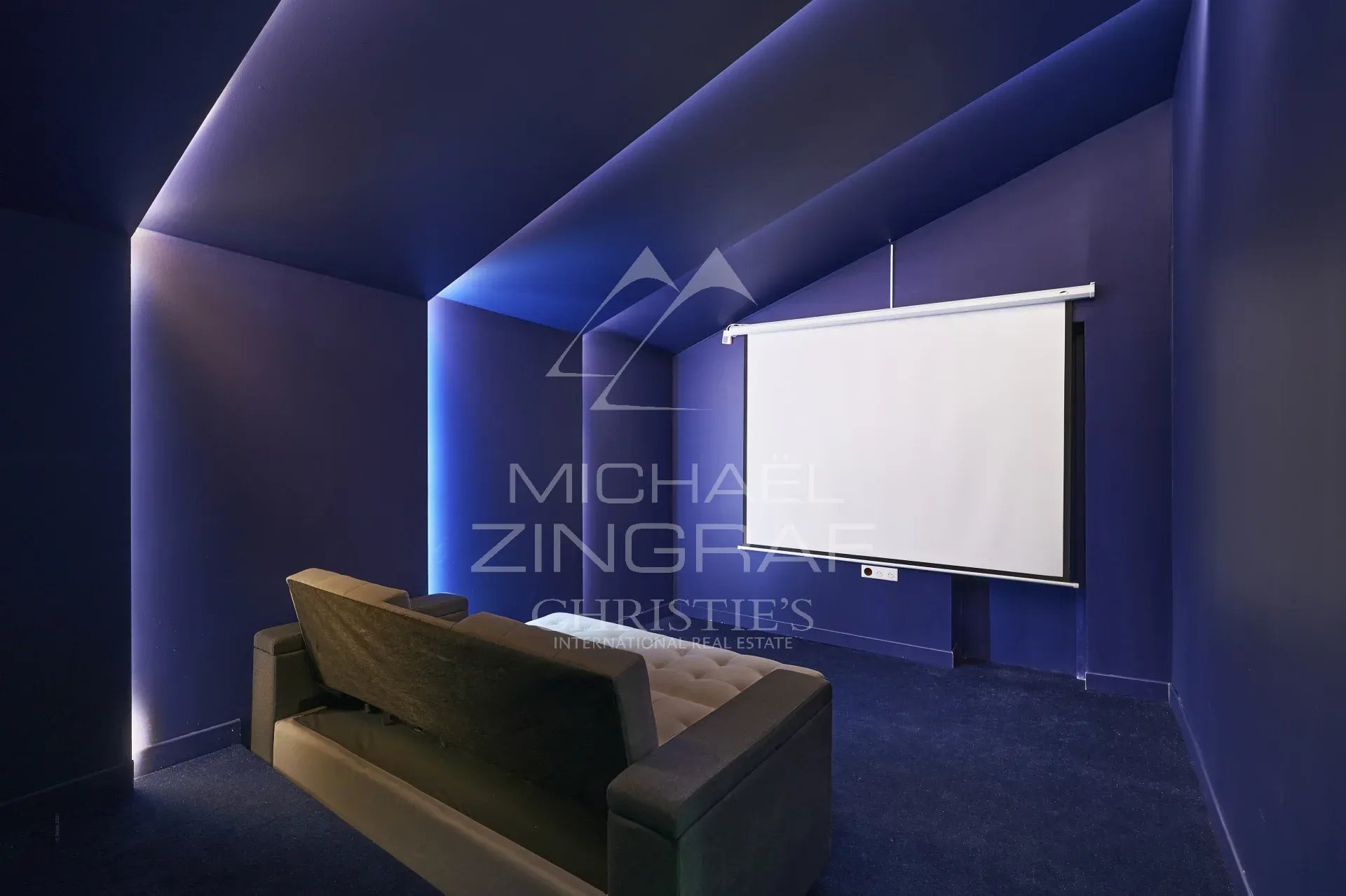 Salle de cinéma dans une villa à Mougins Salle de cinéma privée avec écran et canapé dans une villa à Mougins