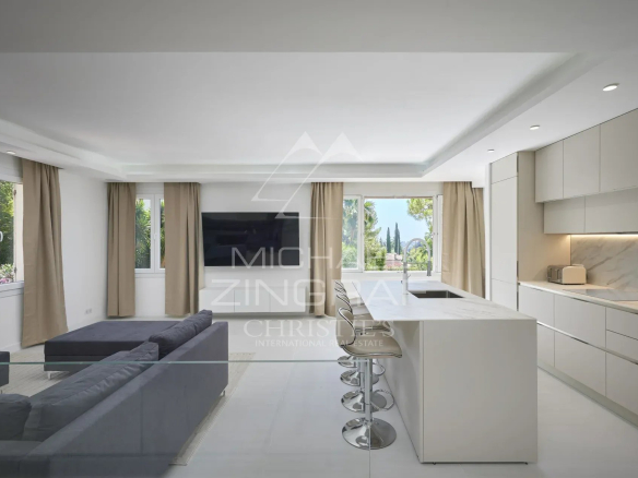 Intérieur moderne d'une villa à Mougins avec salon et cuisine ouverte.