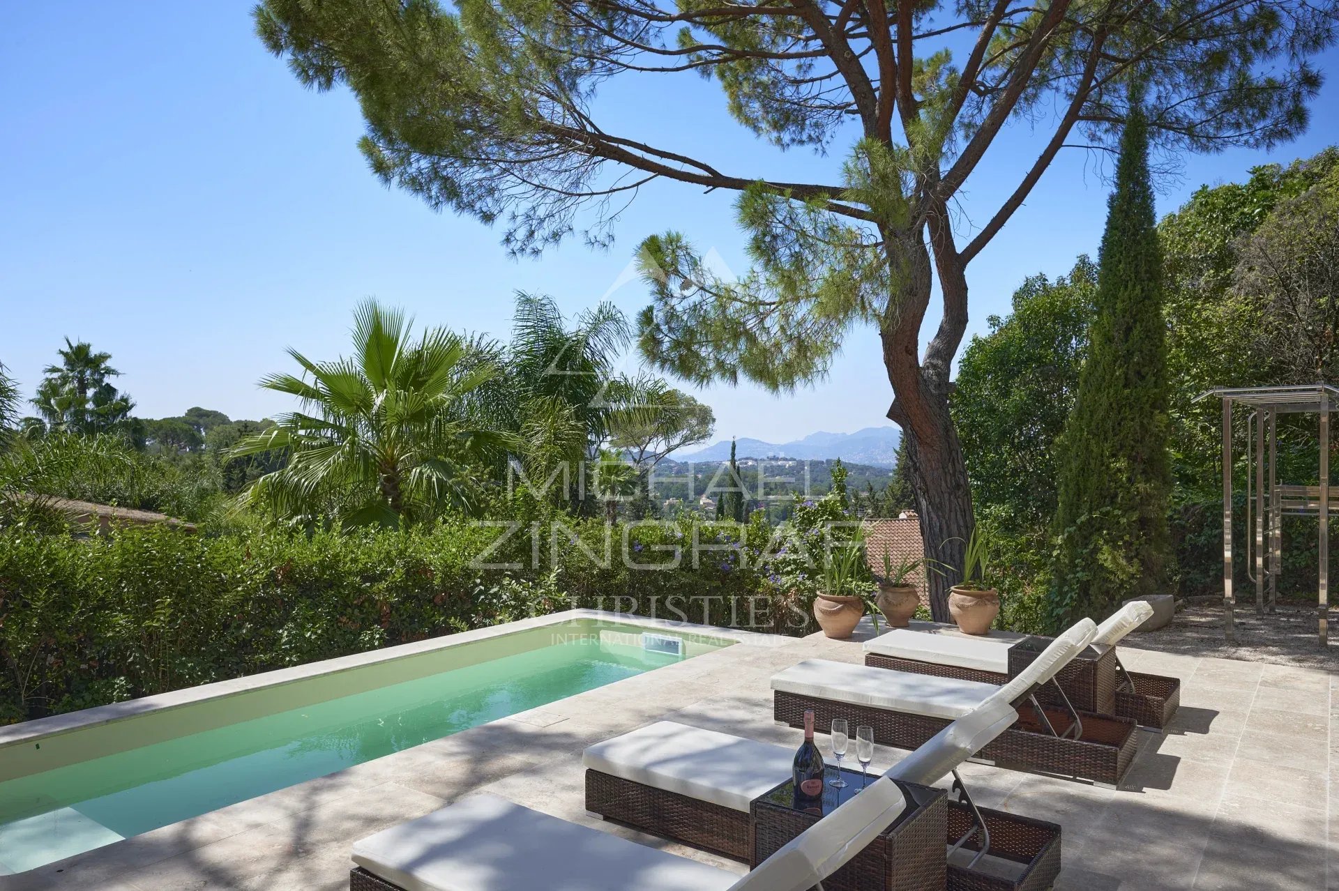 Villa avec piscine à Mougins Vue d'une villa avec piscine et transats, entourée de verdure à Mougins.
