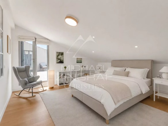 Chambre d'un appartement moderne à Sainte-Maxime, avec lit double et fauteuil confortable.