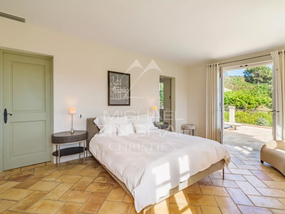 Chambre lumineuse d'une villa provençale à Ramatuelle avec vue sur le jardin.