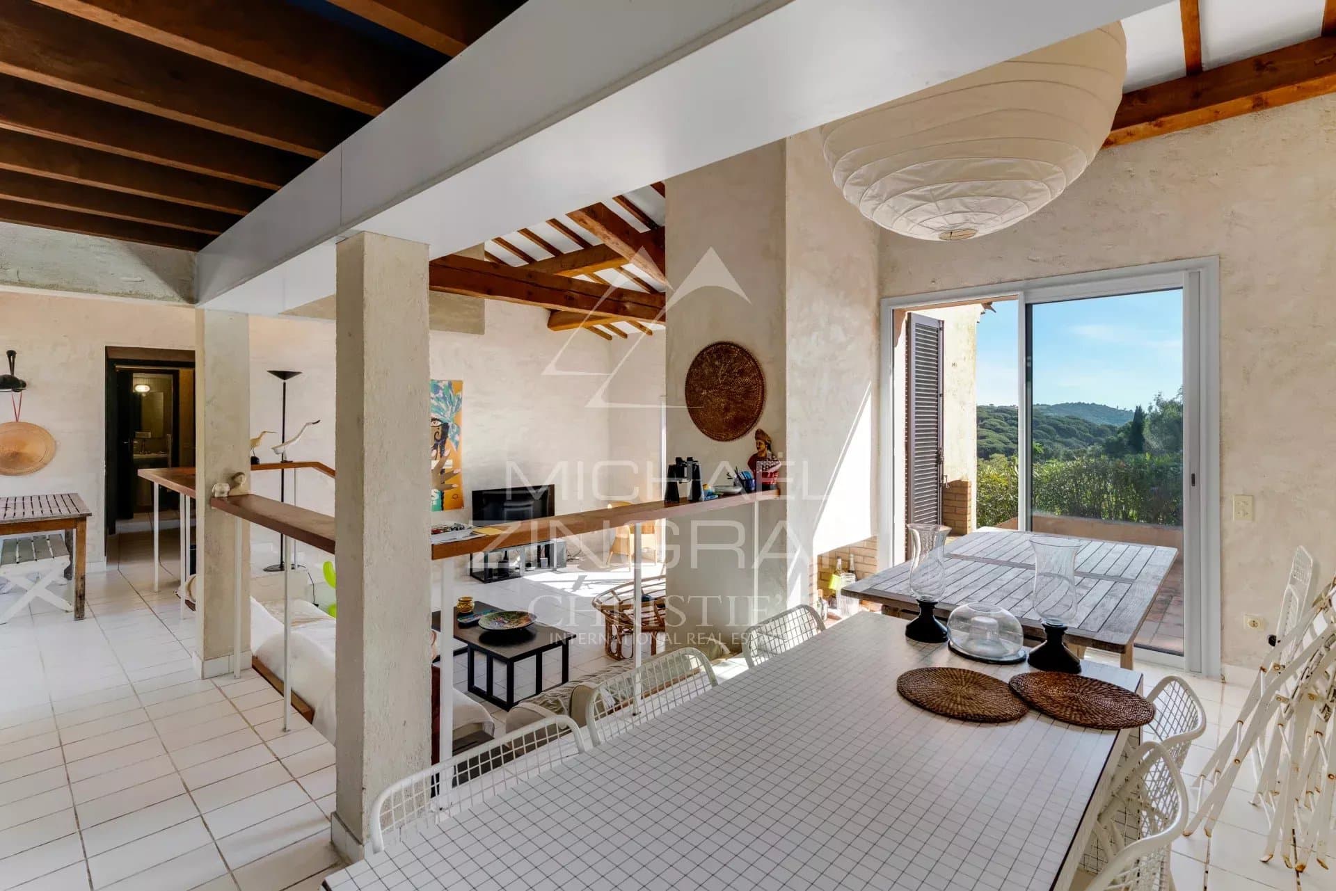 Intérieur d'une maison à Ramatuelle avec vue sur la mer, mobilier moderne et lumière naturelle.