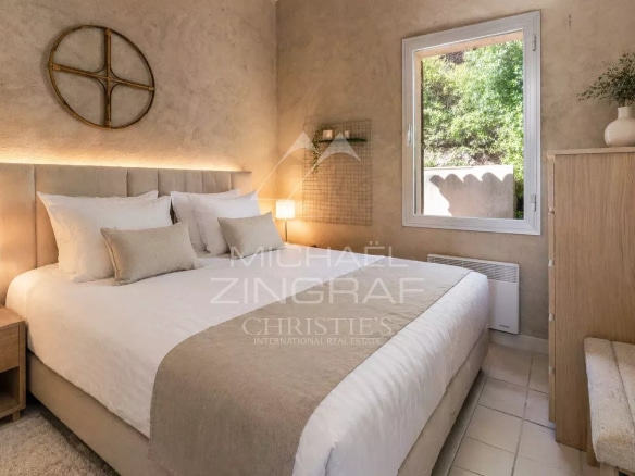 Chambre d'une maison rénovée avec murs en stuc et fenêtre donnant sur l'extérieur.
