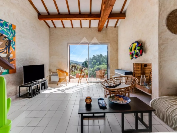 Intérieur d'une maison avec vue sur la mer, salon lumineux et mobilier moderne.