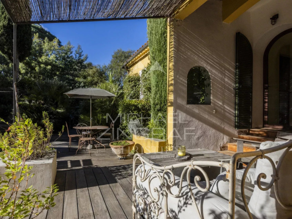 Terrasse d'un appartement rénové avec mobilier de jardin et parasol, entourée de verdure à Gassin.