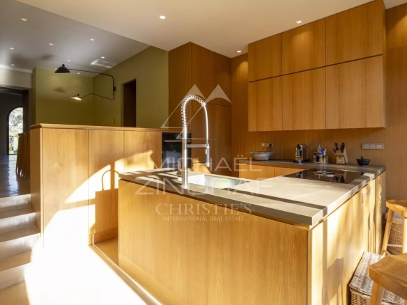 Cuisine moderne en bois dans un appartement rénové à Gassin avec vue sur la mer.