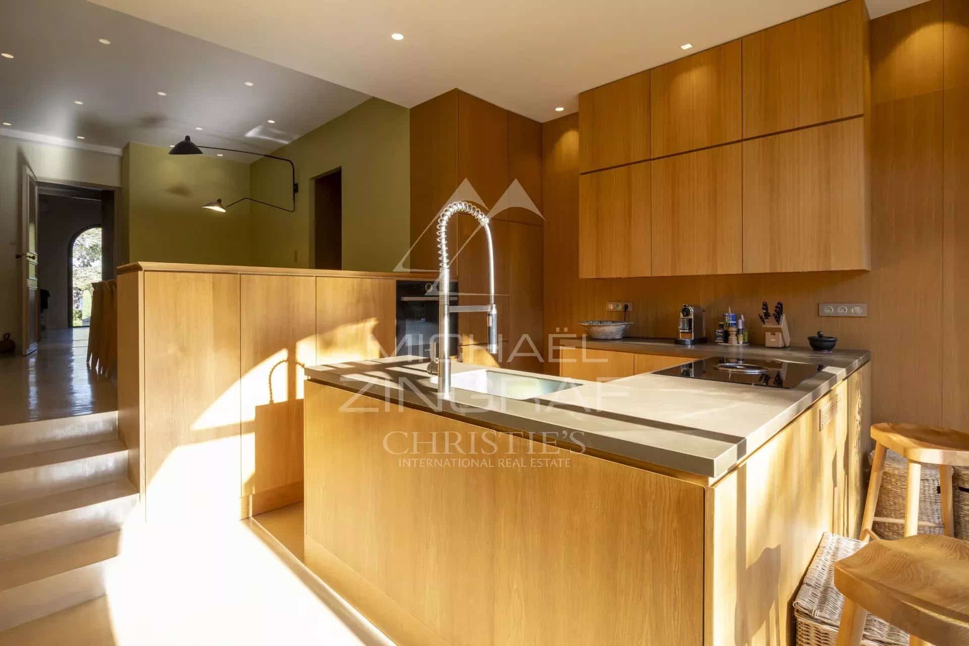 Cuisine moderne en bois dans un appartement rénové à Gassin avec vue sur la mer.