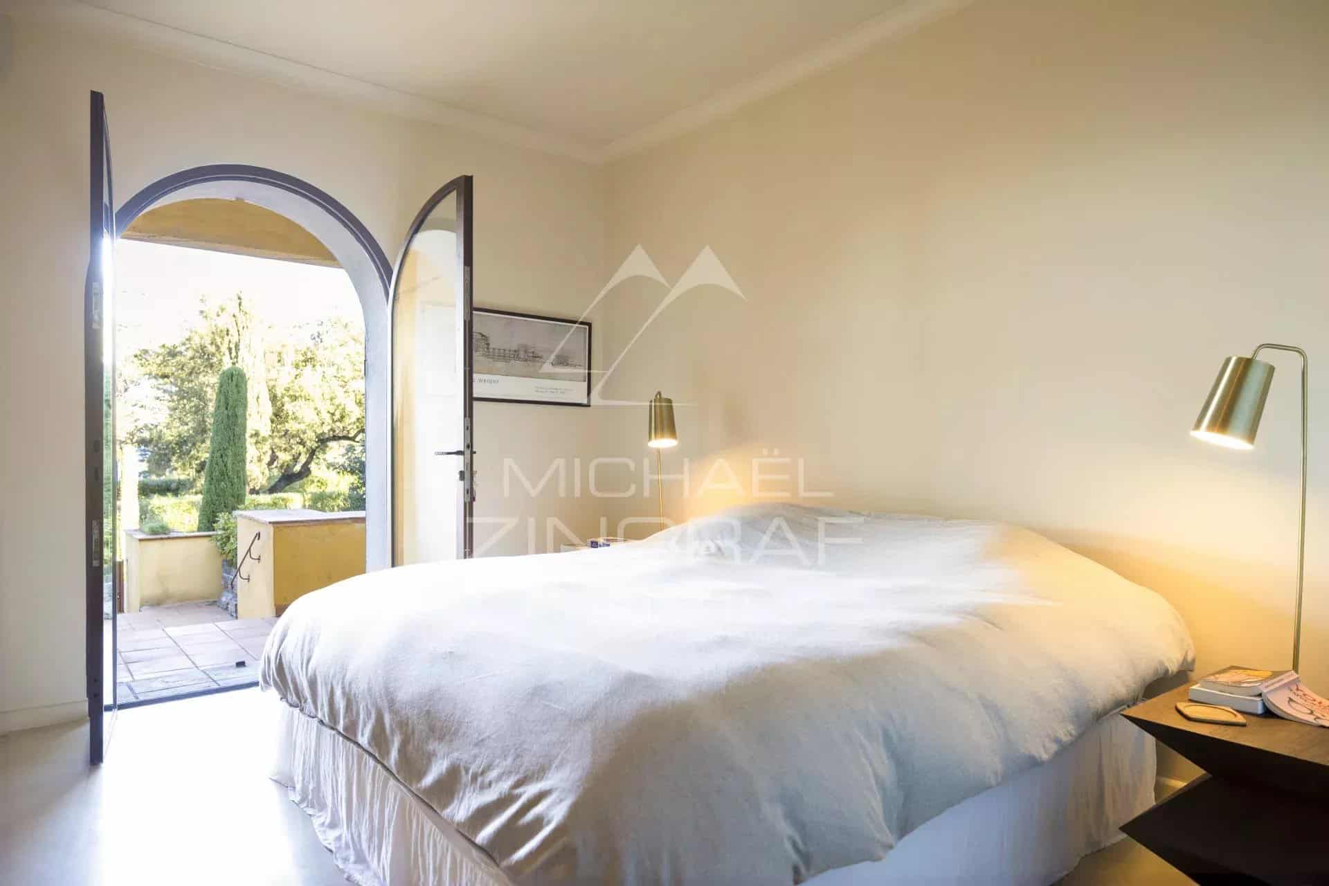 Chambre d'un appartement rénové avec vue sur la mer à Gassin, avec une porte ouverte sur l'extérieur.