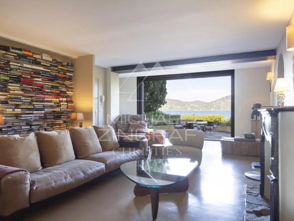 Salon d'un appartement rénové avec vue sur la mer à Gassin, murs décorés de livres.