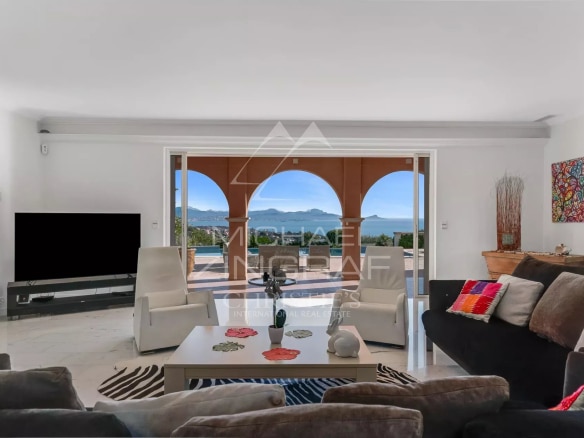 Intérieur d'une villa avec vue panoramique sur la mer, salon lumineux et moderne.