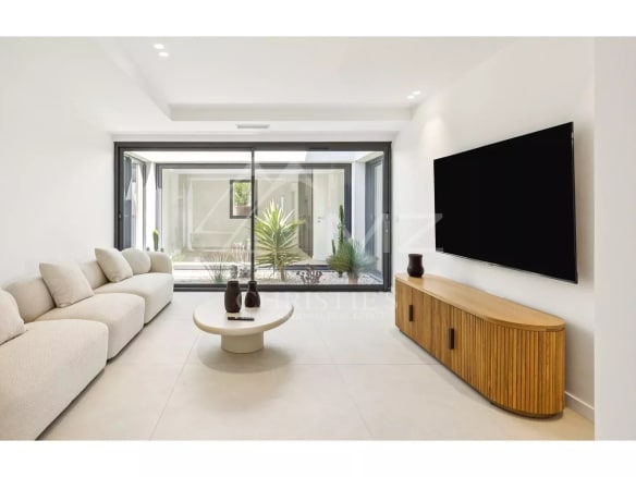 Interior of a contemporary villa with a bright and modern living room, overlooking a garden.