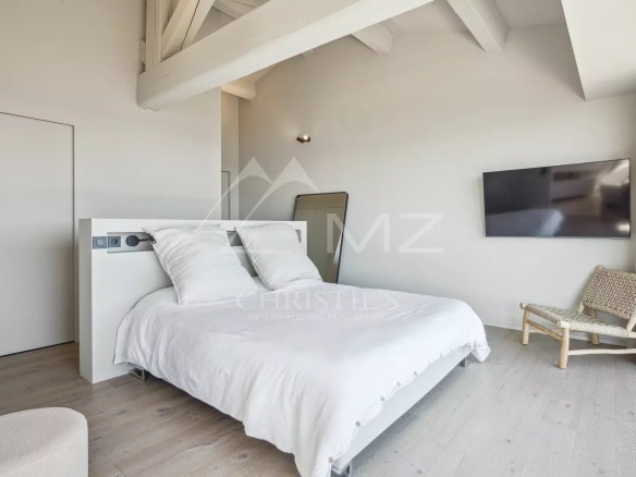 Modern room with double bed and wall-mounted television, minimalist decor.
