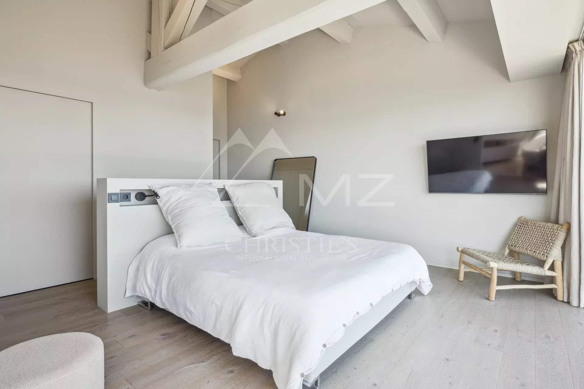 Modern room with double bed and wall-mounted television, minimalist decor.