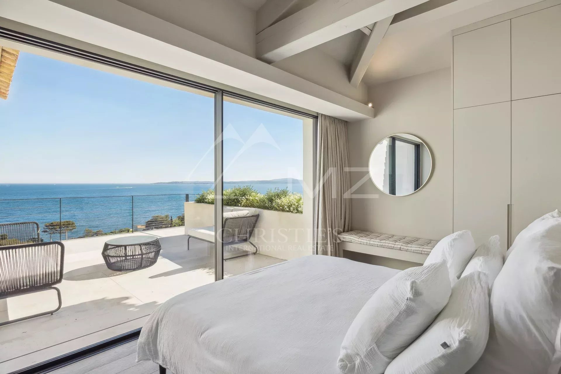 Room with sea view, windows opening onto a terrace, contemporary decor.