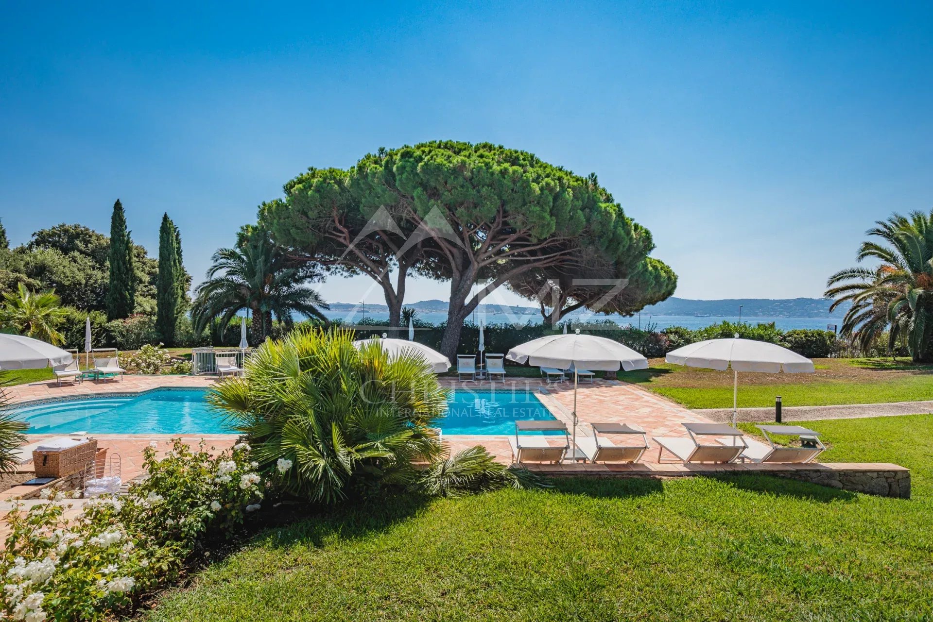 Villa de luxe avec piscine et vue sur la mer, entourée de verdure à Grimaud.