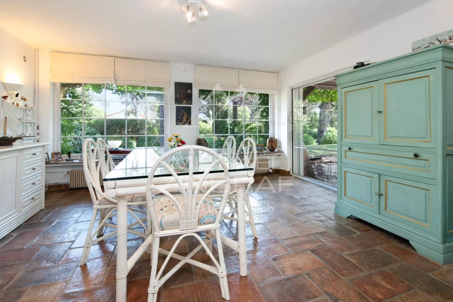 Salle à manger d’une villa à Sainte-Maxime Intérieur d'une villa avec salle à manger lumineuse et vue sur un jardin paysager.