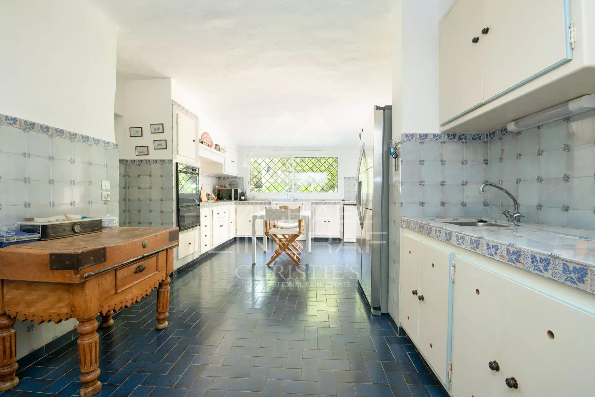 Cuisine d’une villa à Sainte-Maxime Intérieur d'une cuisine spacieuse avec carrelage bleu et mobilier en bois dans une villa à Sainte-Maxime.