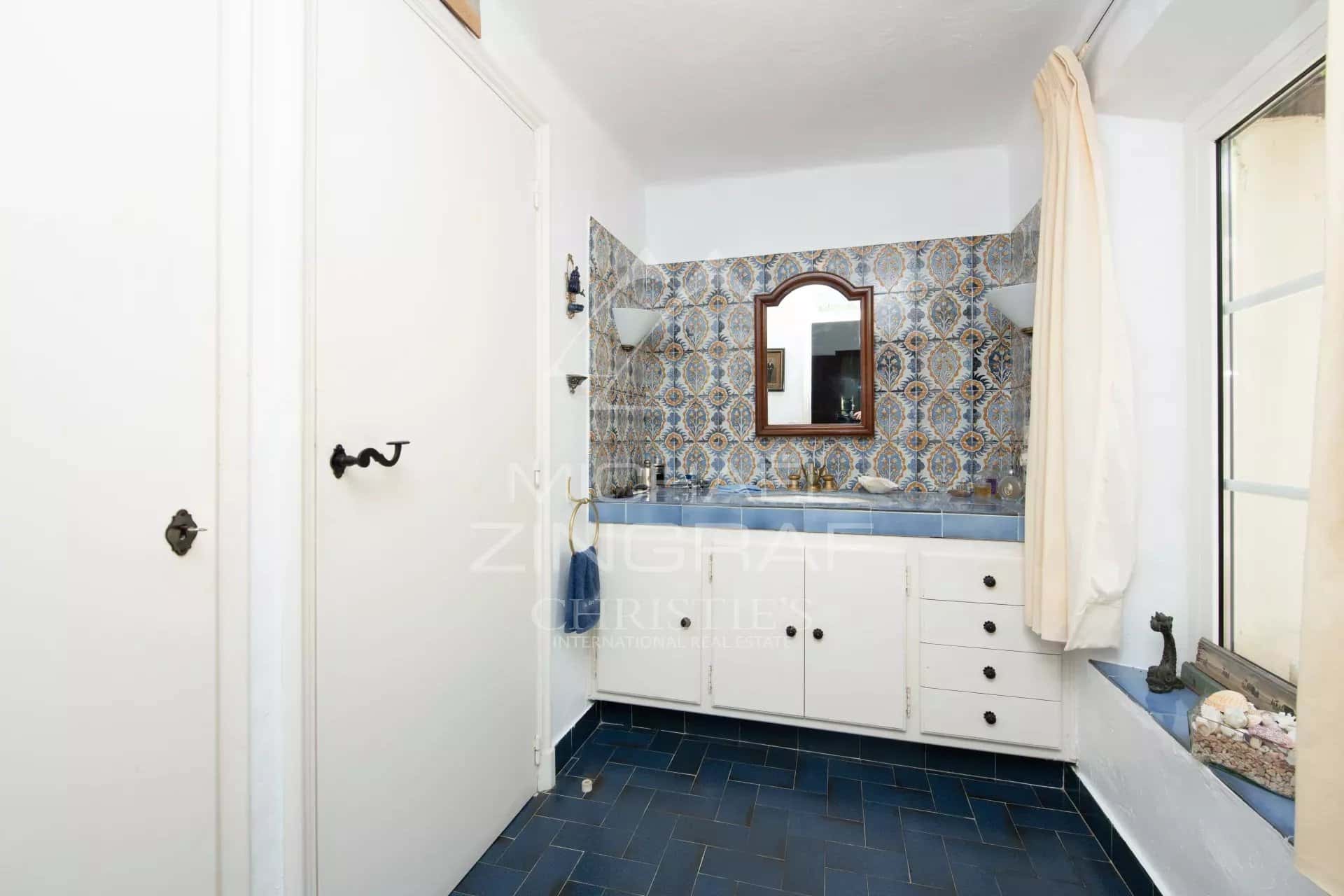 Salle de bain élégante dans une villa de Sainte-Maxime Salle de bain avec carrelage bleu et décorations murales colorées dans une villa à Sainte-Maxime.