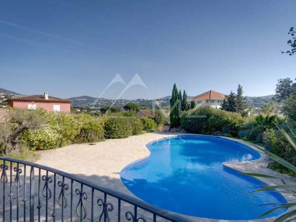 Vue d'une piscine dans une propriété à Sainte-Maxime, avec des jardins et des maisons environnantes.