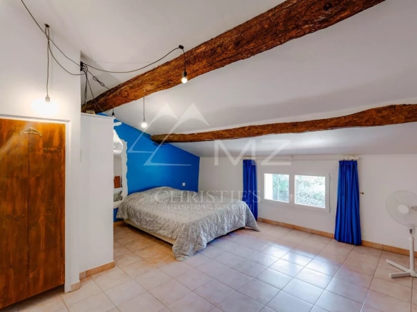Chambre spacieuse avec lit double et poutres apparentes à Sainte-Maxime.