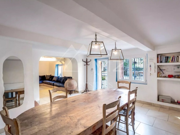 Intérieur d'une propriété à Sainte-Maxime avec une grande table en bois et un salon confortable.
