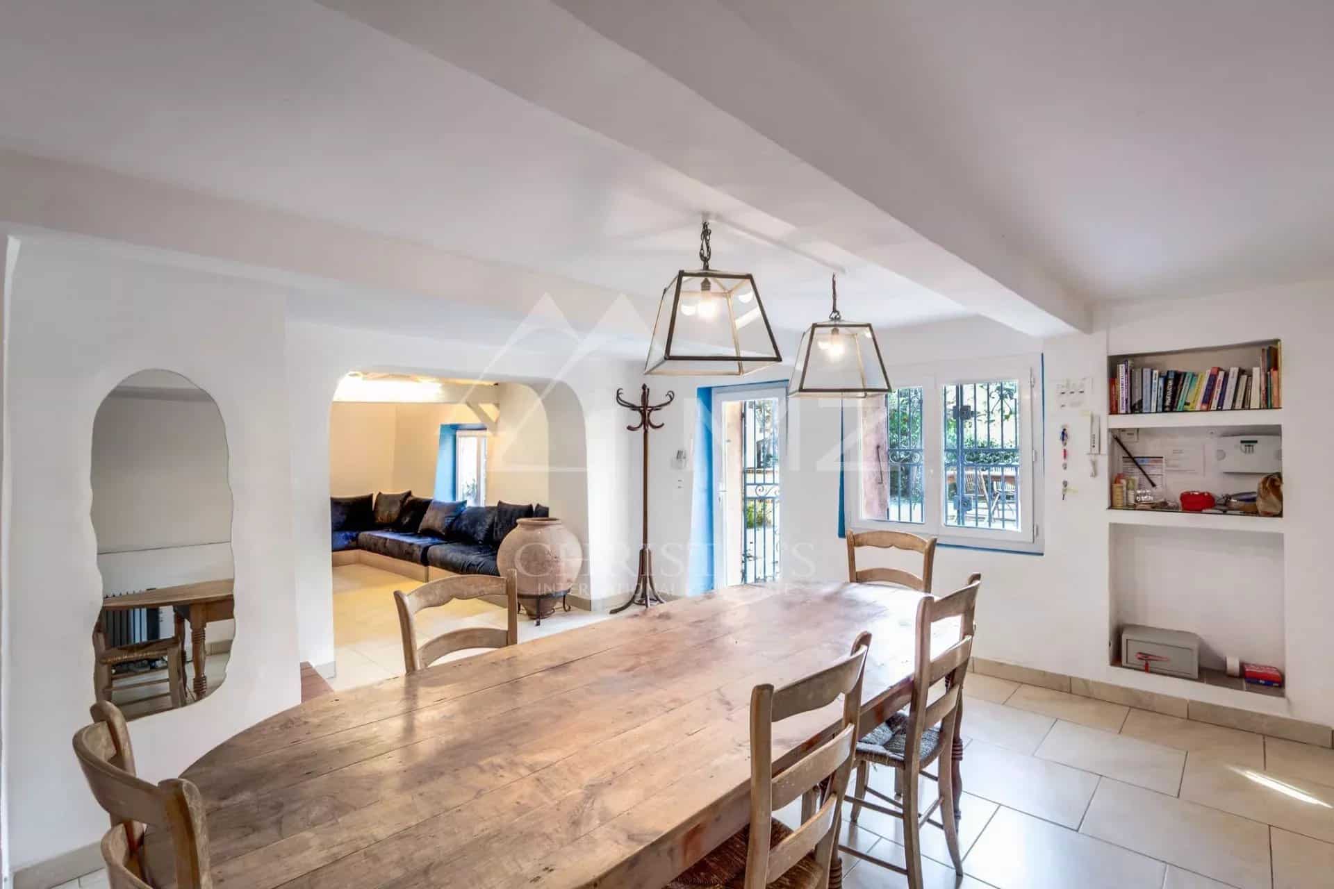 Intérieur d'une propriété à Sainte-Maxime avec une grande table en bois et un salon confortable.