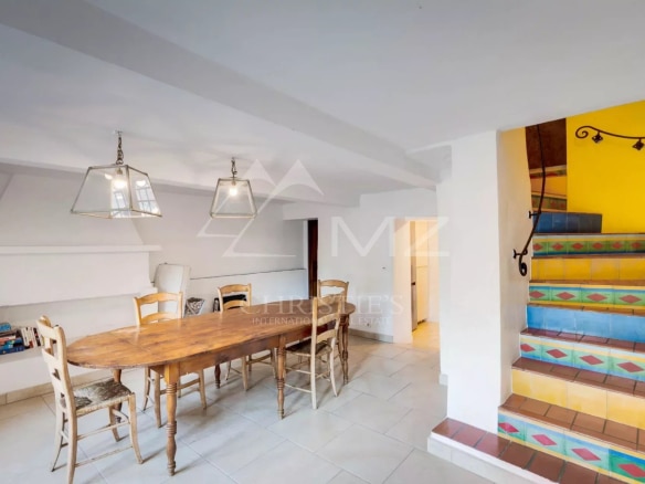 Intérieur d'une propriété à Sainte-Maxime avec une salle à manger et un escalier coloré.