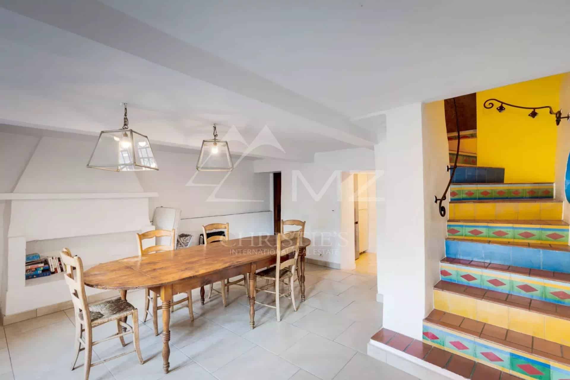 Intérieur d'une propriété à Sainte-Maxime avec une salle à manger et un escalier coloré.