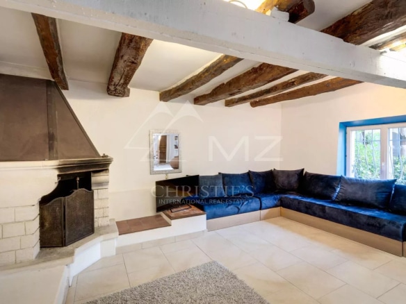 Intérieur d'une propriété à Sainte-Maxime avec cheminée et canapé confortable.