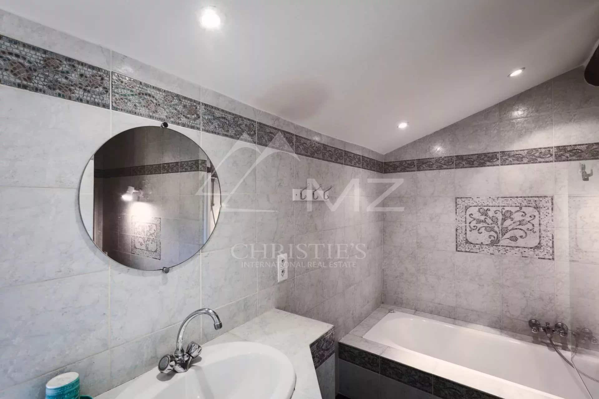 Salle de bain avec baignoire et miroir, carrelage en faïence à Sainte-Maxime.